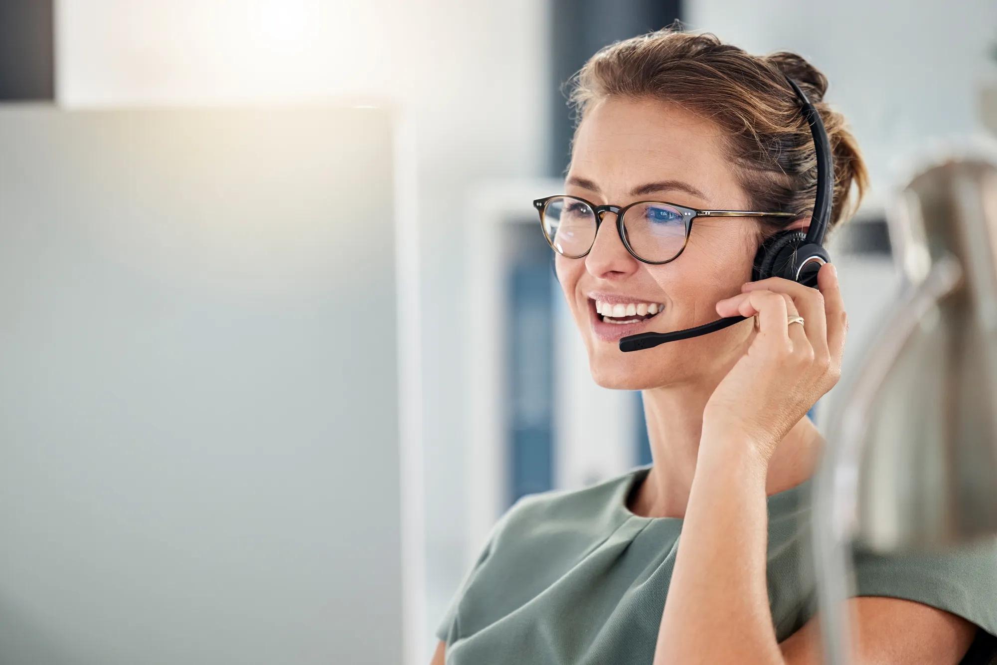 Happy call center woman consulting customer for customer support, help or telemarketing sales. Sales advisor, CRM girl with smile for success customer service, contact us hotline or insurance deal.