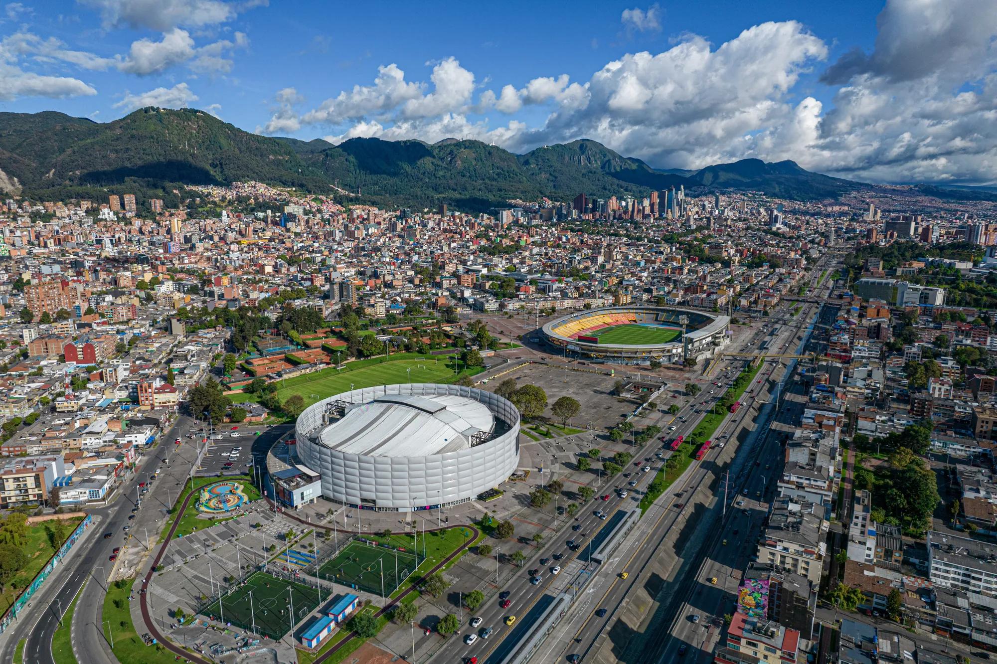 Adobe Stock 523236259 Carrera 30 de la ciudad de Bogotá ( Colombia), donde se puede visualizar el movistar arena y el estadio el campin y el lago del parque de los novios en primer plano y al fondo el centro de la ciudad.