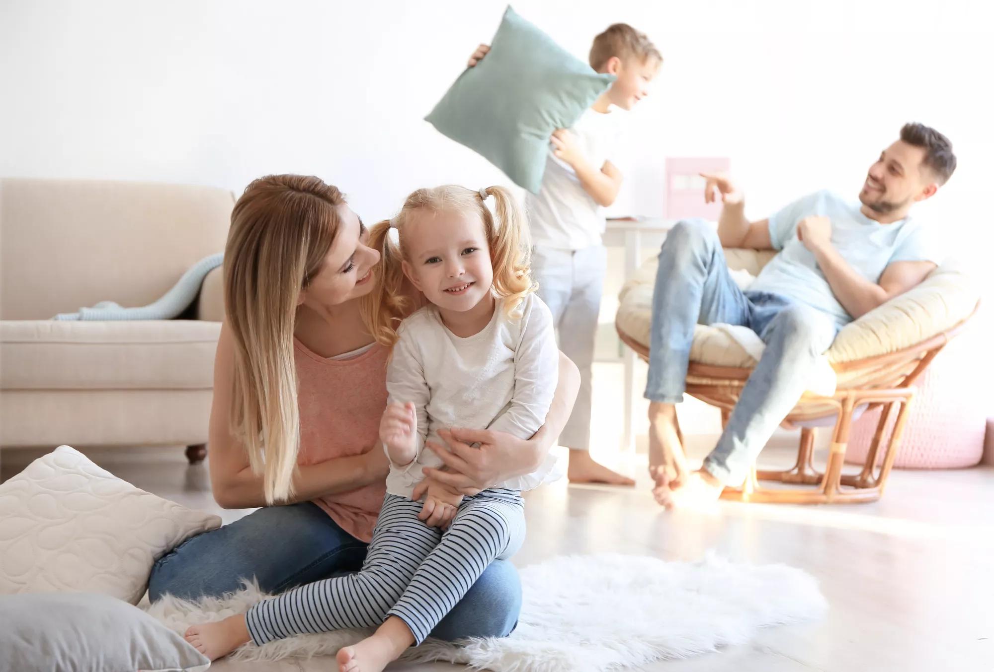 Happy family playing with pillows at home