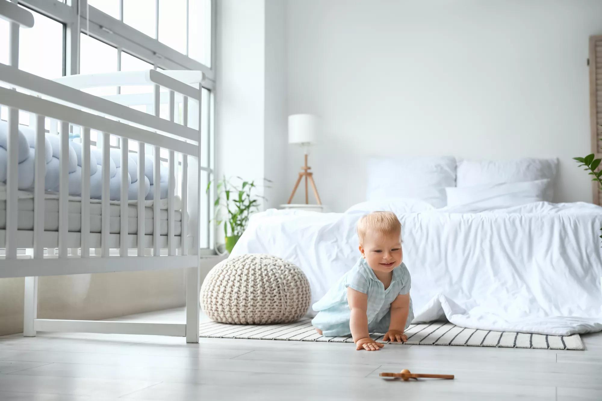 Cute baby girl crawling in bedroom