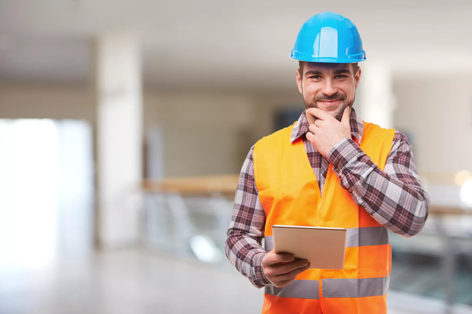 Manual worker in blue helmet with digital tablet