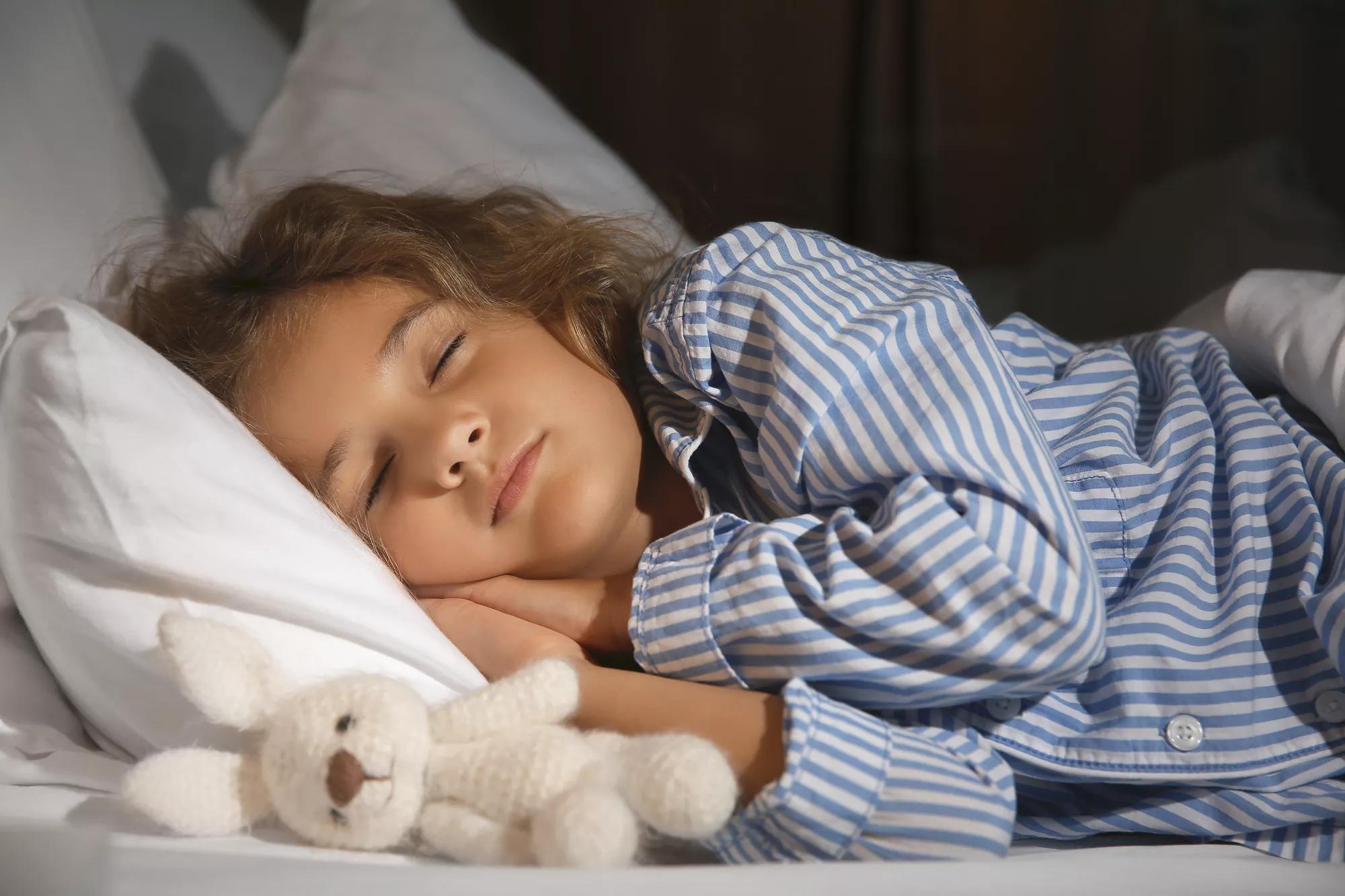 Cute little girl sleeping in bed at night