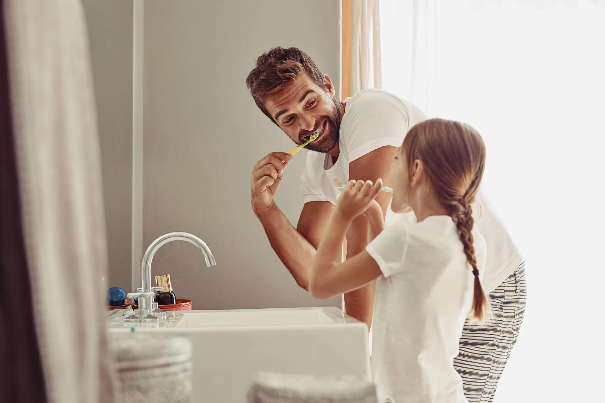 Shot of a happy father and his little girl washing their hands together in the bathroom.