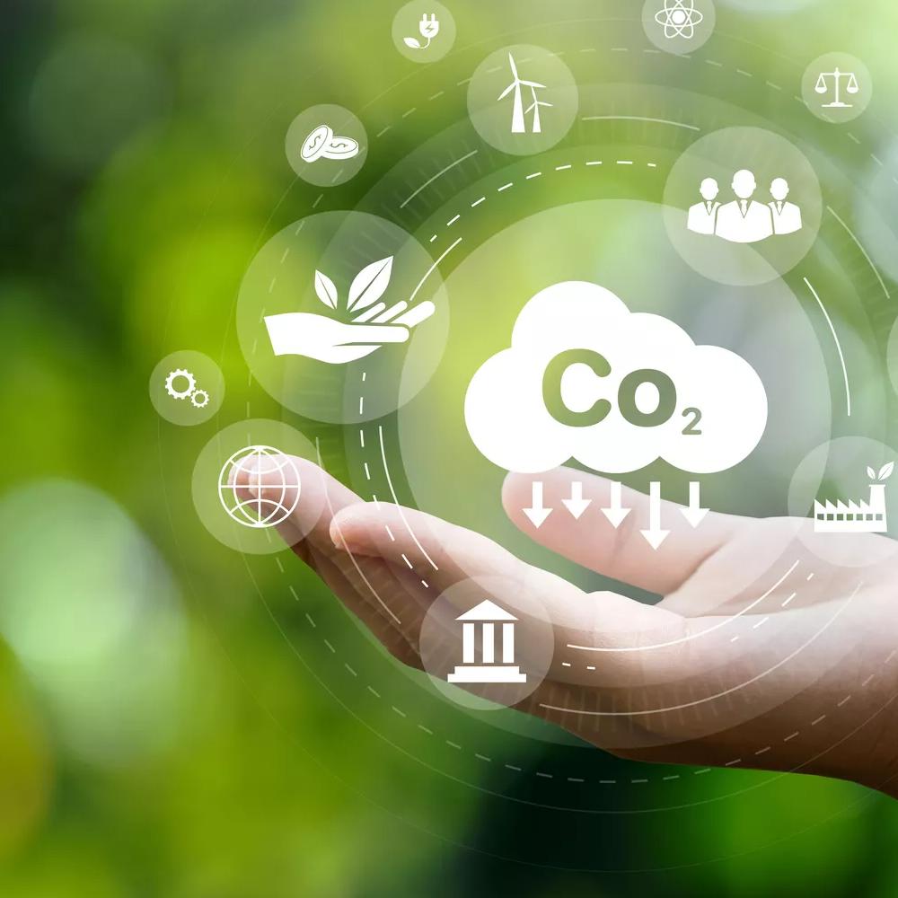 CO2 emission reduction concept in hand with environmental icons, global warming, sustainable development, connectivity and renewable energy green business background.