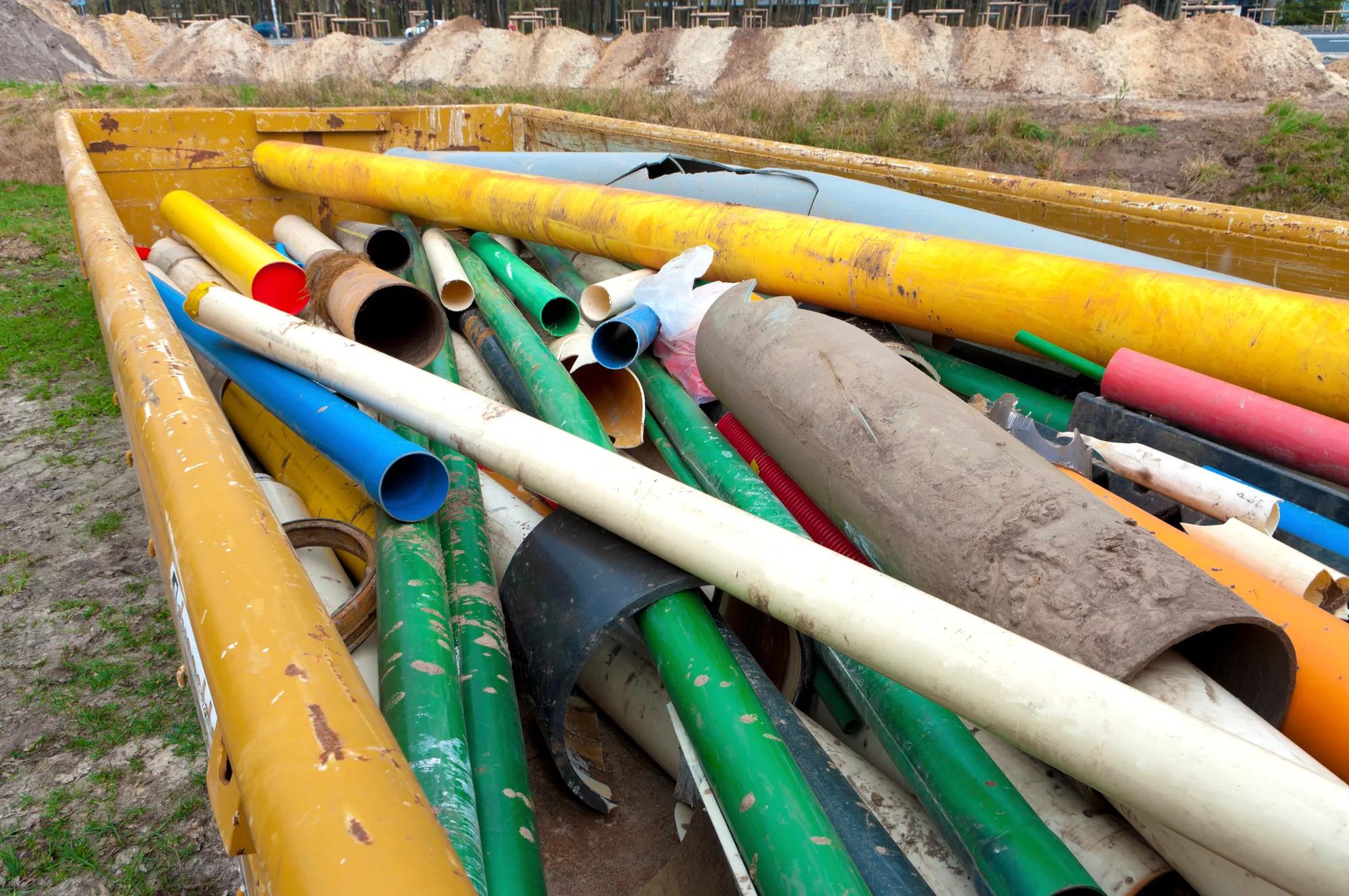 container with used and broken pvc pipes to be recycled