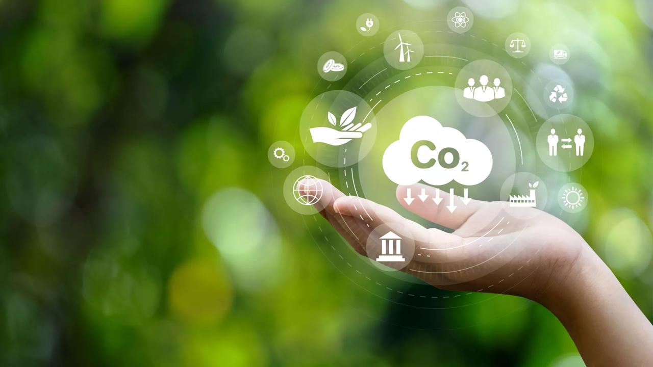 CO2 emission reduction concept in hand with environmental icons, global warming, sustainable development, connectivity and renewable energy green business background.