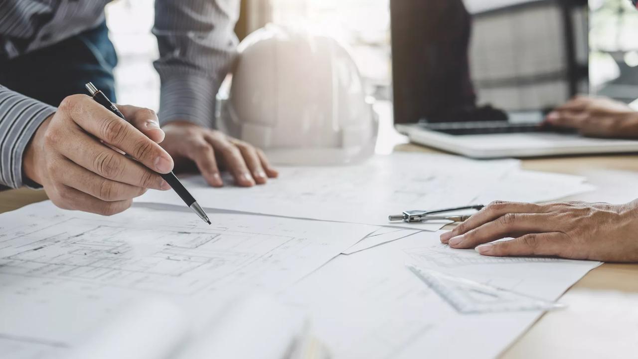 Hands of architect or engineer working on blueprint meeting for project working with partner on model building and engineering tools in working site, Construction and structure concept.