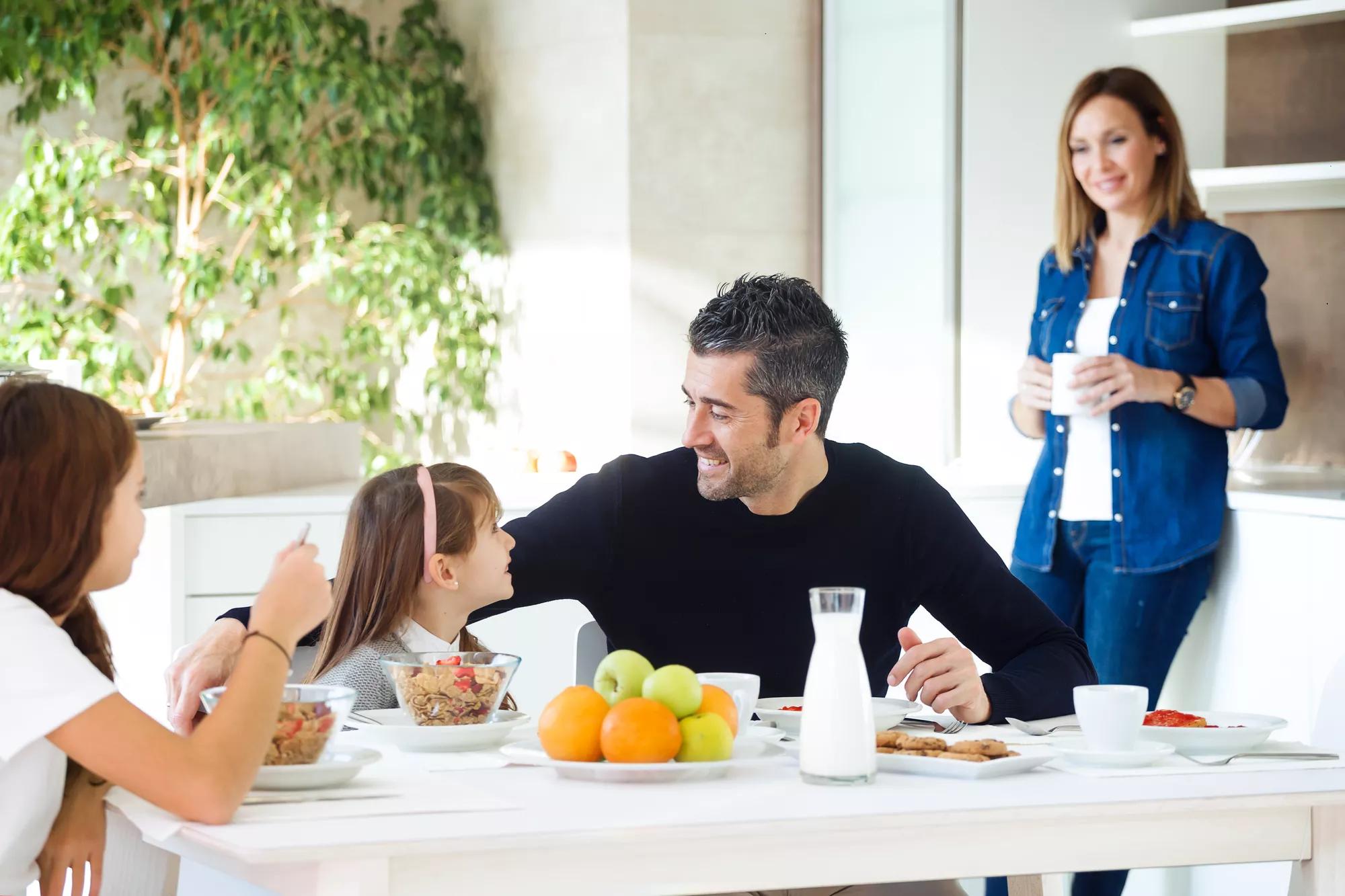 Shot of happy family eating breakfast and having fun in kitchen table at home.