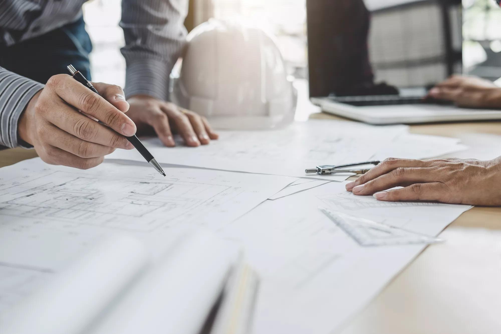 Hands of architect or engineer working on blueprint meeting for project working with partner on model building and engineering tools in working site, Construction and structure concept.