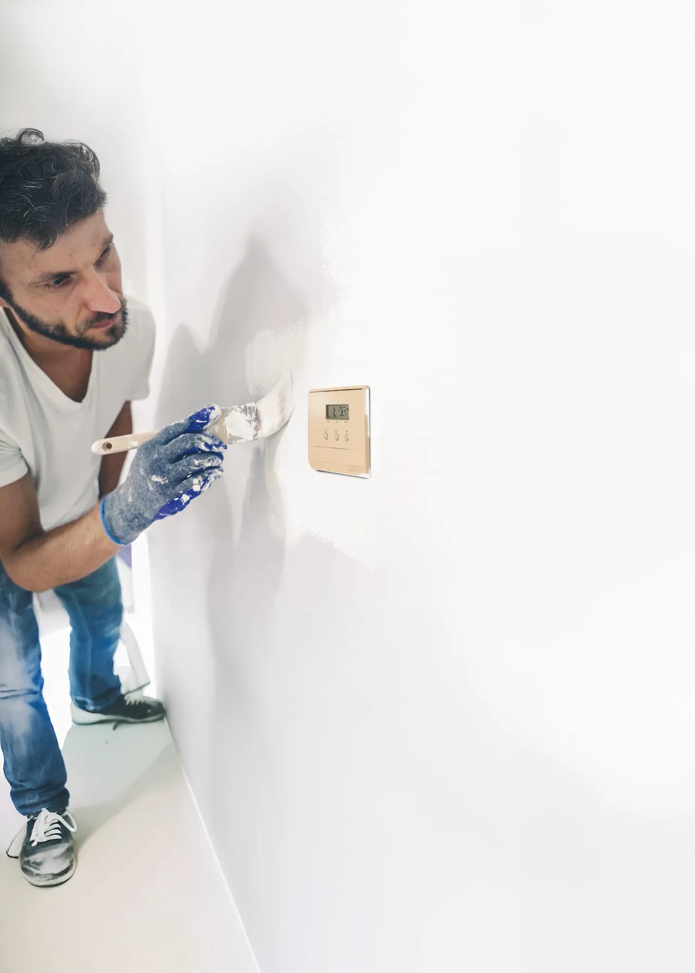 Image used for Refurbishment with Sentio campaign
Man painting a wall with an old eyesore thermostat