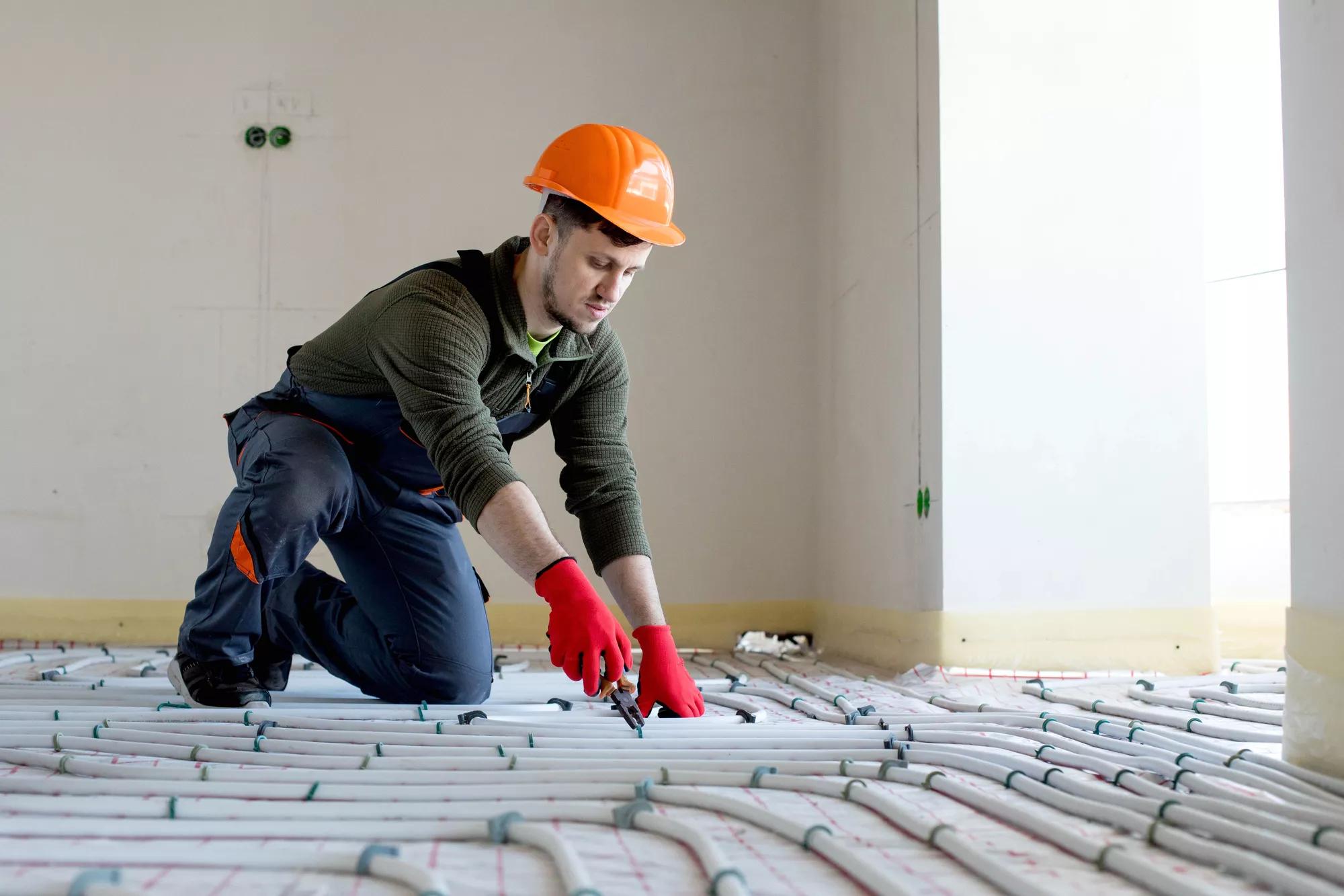 Worker is installing underfloor heating system. Warm floor heating system.