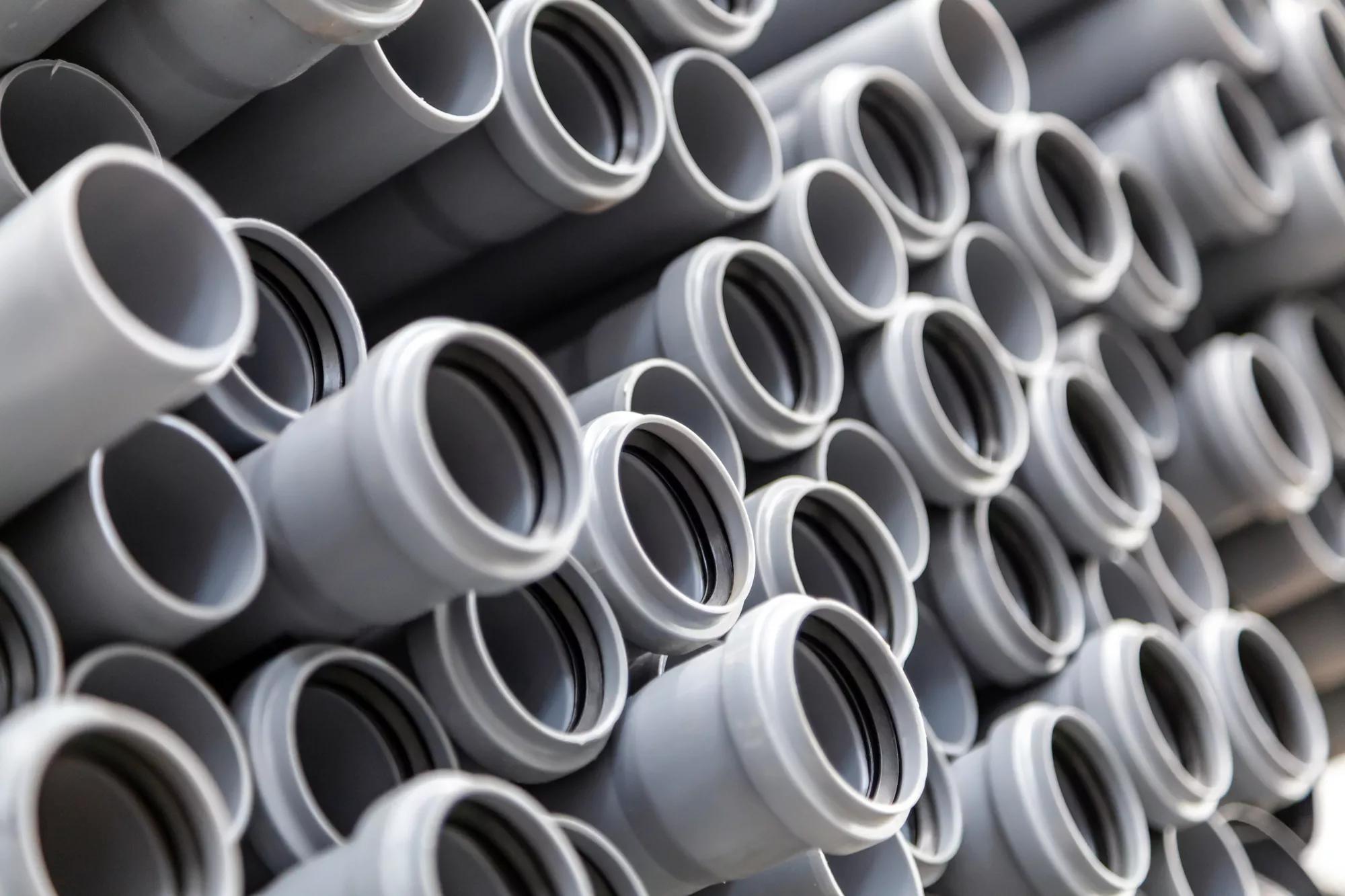 Close up gray plumbing plastic pipes. Background of colorful big plastic pipes used at the building site.