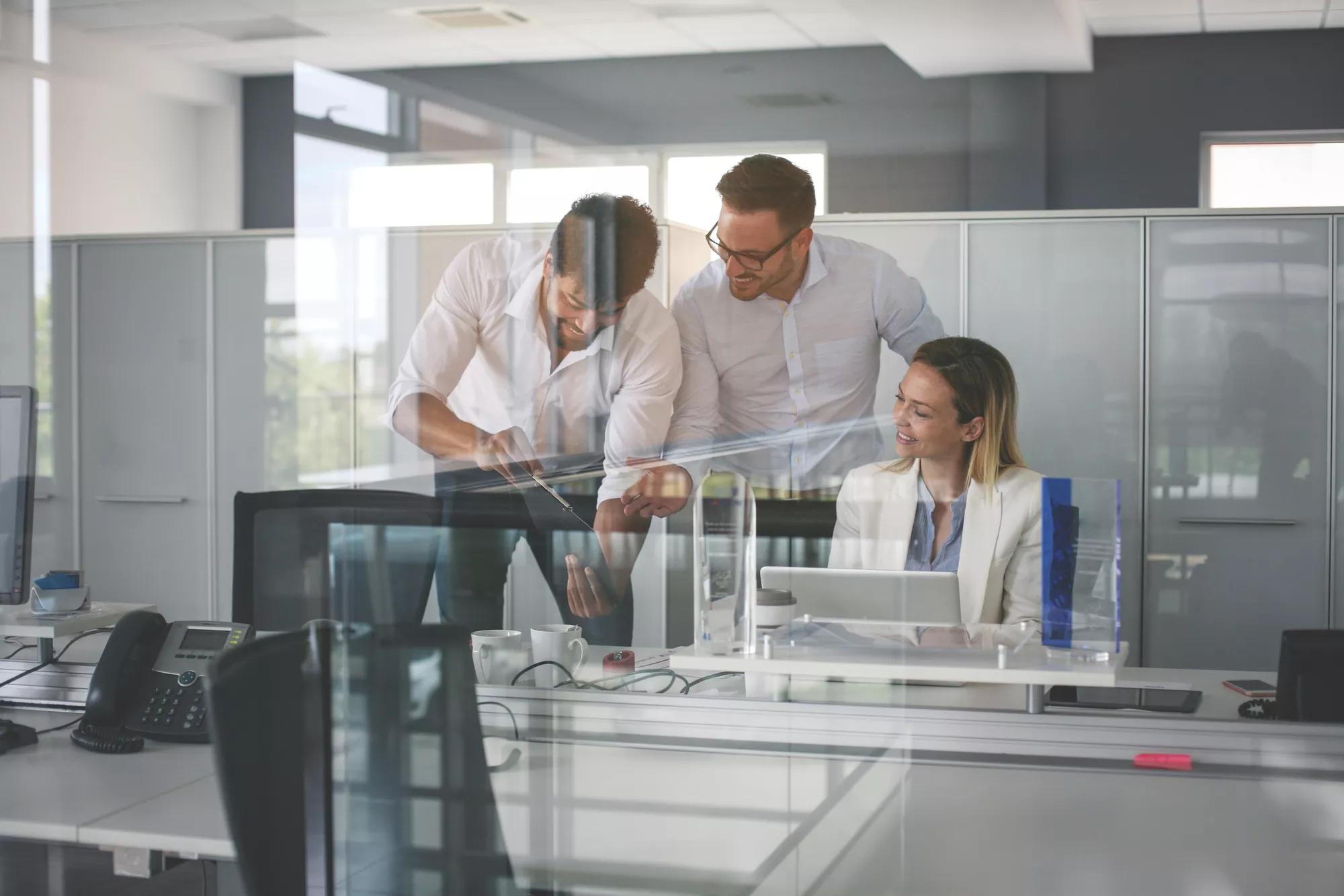 Three colleague in office using computer and checking document. Business people in office.